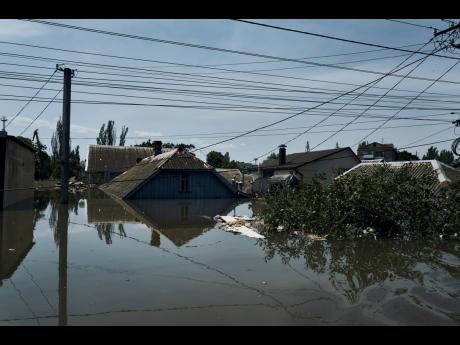 A view of the roofs of flooded private houses in Kherson, Ukraine. Floodwaters from a collapsed dam kept rising in southern Ukraine on Wednesday, forcing hundreds of people to flee their homes in a major emergency operation that brought a dramatic new dime