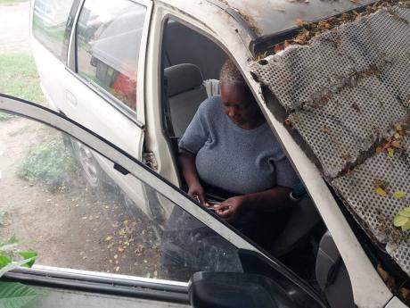 Lamour Pinnock searches for a document stored in the car where she spends her nights, sleeping.