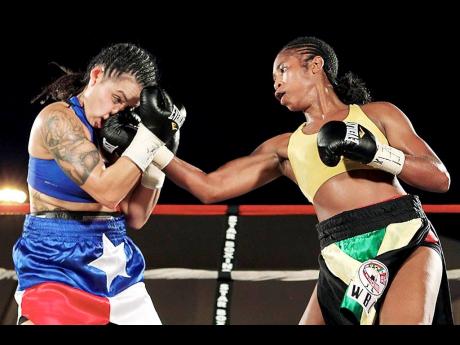 Alicia Ashley (right) lands with a right uppercut during a World Boxing Council super batamweight title fight against American Christina Ruiz in Bronx, New York, on July 23 2011. 