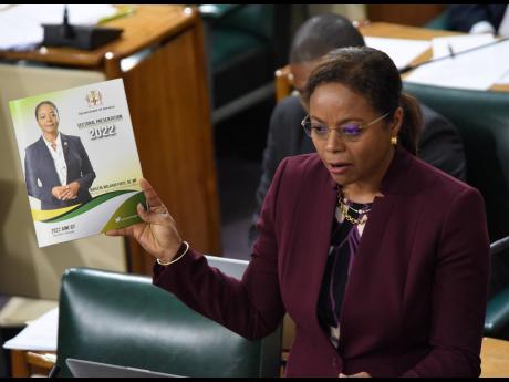 In this 2022 photo, Marlene Malahoo Forte, minister of legal and constitutional affairs, holds a copy of her Sectoral  Debate presentation. 