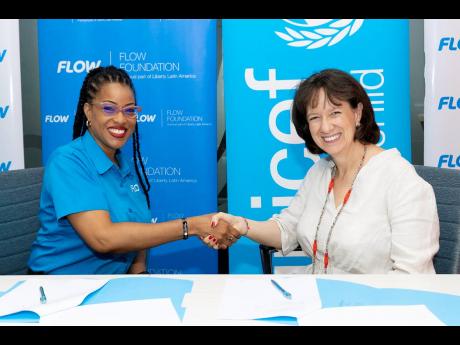 Kayon Mitchell (left), Flow’s director of communications and executive director of the Flow Foundation, is joined by Olga Isaza, UNICEF’s Jamaica representative, at the signing to renew the memorandum of understanding at Flow’s corporate offices in S
