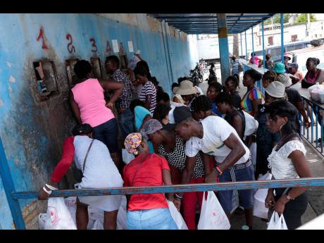 People gather outside the National Penitentiary for their turn to deliver food to their jailed relatives in downtown Port-au-Prince, Haiti, on June 1. 