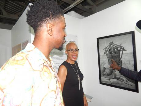 School of Visual Arts final-year student Phillip Robinson talks about his artwork with Education Minister Fayval Williams.