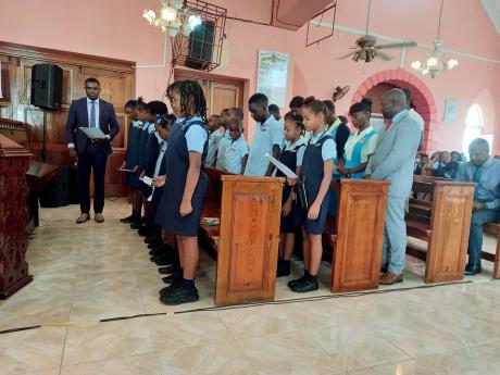 Principal of the Christiana Moravian Primary and Infant School, Fitzroy Abbott (front left), and Principal of the Christiana High School Leecent Wallace (right back) lead their students through the peace ambassadors’ pledge. 