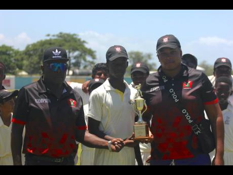 Campion College’s  cricket coach Donald Bredwood (left) alongside captain Abraham Waugh (centre) and assistant coach Derval Ellis pose with the ISSA Under-14 trophy following their nine-wicket win over St Catherine High in the final at Chedwin Park yeste