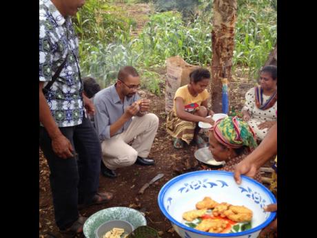 
Stephen Rodriques sampling local food from women in a village in Indonesia.