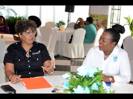 Keynote speaker Patricia Duncan Sutherland (left), chairwoman, JMMD and the Joan Ducan Foundation, speaks with Dr Sasha Shim-Hue, regional director for Region 6, during the Women in Agriculture Conference and awards ceremony at the Tera Nova Hotel in St An