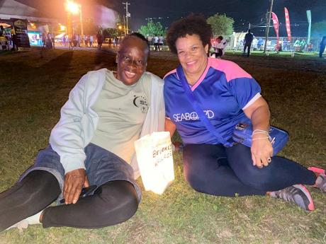 Beverley Wallace (left), 68-year-old breast cancer survivor, sits beside her luminaria bag at the Relay for Life event on Saturday at the Police Officers Club. Also seated is her employer, Corah Ann Sylvester, chief executive officer, Seaboard Jamaica. 