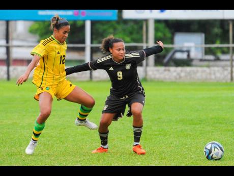 Drew Spence (right) keeps Kalyssa Van Zanten at bay during a recent Reggae Girlz training camp at the Anthony Spaulding Sports Complex. Both players made coach Lorne Donaldson's squad for the FIFA Women's World Cup in Australia and New Zealand in July.