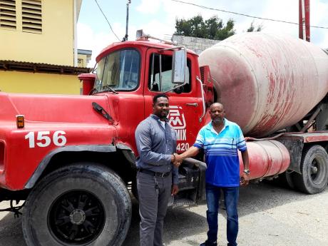 Anthony Anderson (left), regional manager at Jamaica Pre-Mix Concrete Limited, shakes hands with Howard Cooke Primary School Principal Dave Scott. Jamaica Pre-Mix Limited has contributed over $1.5 million towards the school’s construction of new classroo