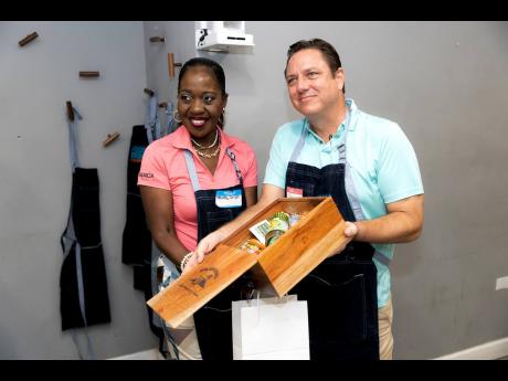 Group Marketing Director of Walkerswood, Sean Garbutt, presents Trudy Dixon, Caribbean sales manager at the Jamaica Tourist Board, with a prize for getting the right answers during the Walkerswood and Jamaica Food and Drink Kitchen trivia.