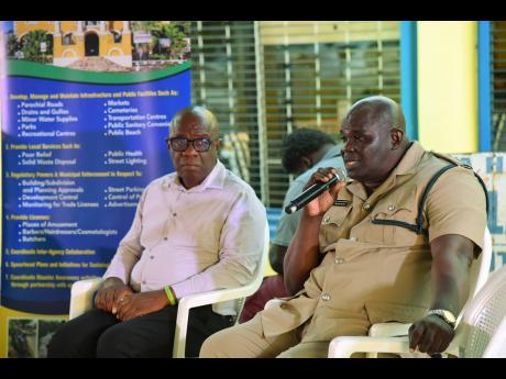 Winston Milton (right), deputy superintendent of police and head of the Trelawny Police Division, addresses residents during a town hall meeting. At left is Falmouth mayor, Collen Gager.