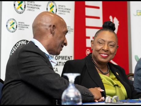 Minister of Culture, Gender, Entertainment and Sport Olivia Grange (right) interacts with Garth Gayle, president, the Jamaica Athletics Administrative Association, at yesterday’s media launch for the 2023 National Junior and Senior Championships at The J