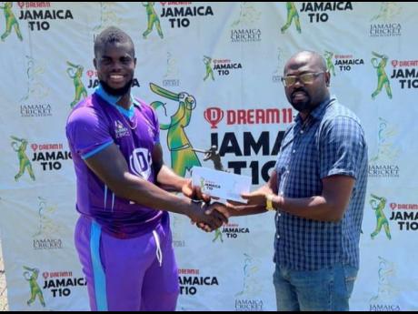 Surrey Kings all-rounder Jeavor Royal (left) accepts his Player of the Match award from Jamaica Cricket Association director Lawrence Garriques at Sabina Park yesterday. 