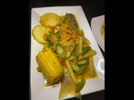 Curried steamed fish with okra and carrot is accompanied by steamed bammy and corn on the cob. 