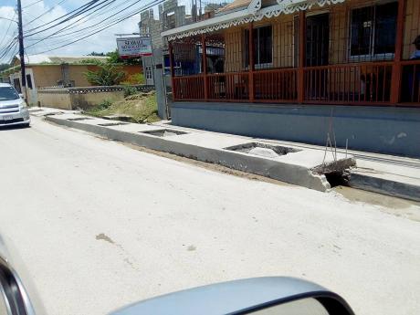 Pedestrians must exercise extra care along Main Street, Lucea, as the newly constructed concrete drains are uncovered.