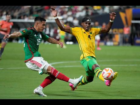 Jamaica’s Amari’i Bell (right) blocks a shot by Mexico’s Uriel Antuna during the first half of their Concacaf Gold Cup semi-final match on Wednesday night in Las Vegas.