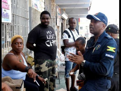 File photo shows Senior Superintendent of Police, Vernon Ellis, having a discussion with street vendors in Sam Sharpe Square in Montego Bay. Ellis told Thursday’s monthly sitting of the St James Municipal Corporation that consideration should be given to