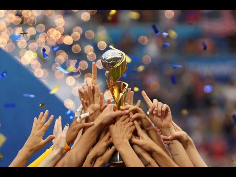 In this July 7, 2019, file photo, the United States players hold the trophy as they celebrate winning the Women’s World Cup at the Stade de Lyon in Decines, outside Lyon, France. The 2023 Women’s World Cup will be spread across nine cities in Australia