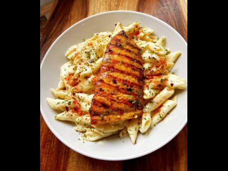 This scrumptious grilled salmon is accompanied by creamy pasta.