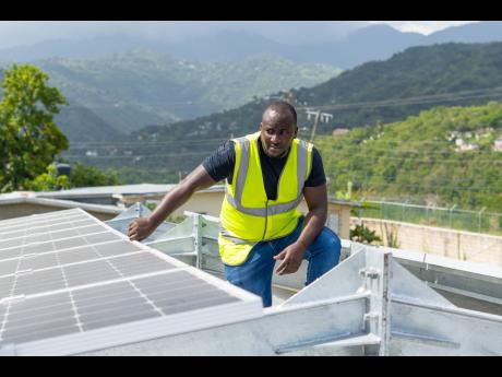 Electrician Curtis Blackburn inspecting solar panels which help to light up the conference room plus key operations at the Sir John Golding Rehabilitation Centre.