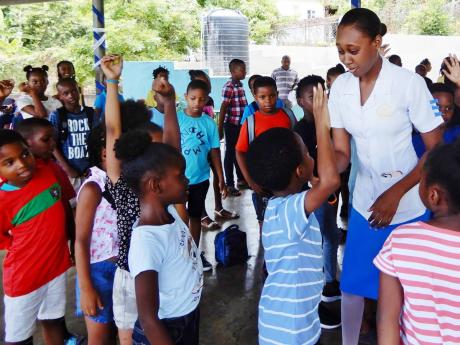 NAJ/Lasco Nursing Student of the Year 2022-23, La-Daniel Campbell of Brown’s Town Community College, interacting with students at Exchange All-Age School during the event.