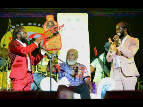 Freddie McGregor, flanked by sons Stephen (left) and Daniel, following the presentation of the Red Stripe Living Legend Award to their father.