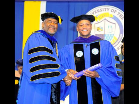 Wes Moore (right), 63rd governor of the state of Maryland in the United States, was conferred with a doctor of laws degree by Professor Haldane Davies, president of the University of the Commonwealth Caribbean (UCC), at the institution’s commencement cer