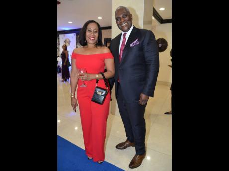 Justice Nicole Simmons of the Court of Appeal is glowing in red as she poses with Lowel Morgan, managing partner of Nunes, Scholefield, DeLeon & Co. Attorneys-at-law.