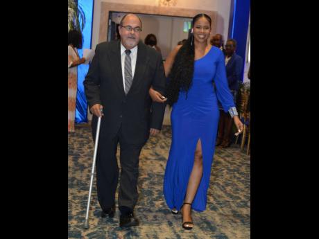 Honoree John Junor (left) is led to the stage by Jaavonne Taylor, associate attorney at Nunes, Scholefield, DeLeon & Co and co-chair of the JAMBAR Social Affairs Committee.