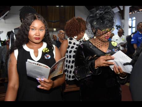 Lee Ann Williams (left) and Mischa Williams (right) daughters of Winston Williams, during his thanksgiving service  at the St Matthew’s Anglican Church in Kingston yesterday.
