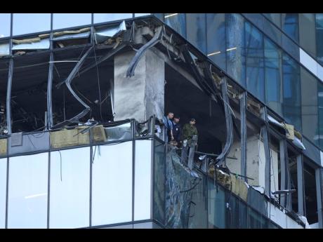 Investigators examine a damaged skyscraper in the "Moscow City" business district after a reported drone attack in Moscow, Russia, earlier today.