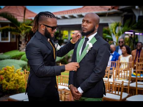 Taking his best man duties seriously, Vernal Phillips (left), prepares the groom for his exciting wedding day.
