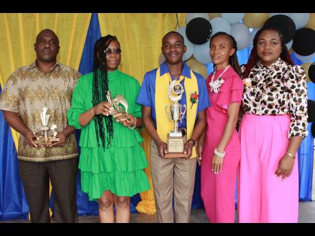 Payton Higgins (centre) displays his trophy at the recent graduation ceremony of Garden Hill Primary and Infant School, held at the school. Sharing the moment (from left) are Payton’s father, Troy Higgins; mother Sherine Higgins; grade-six teacher Simone