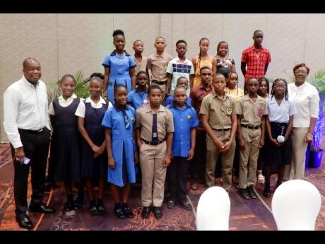 Clifton Reader (left), vice president, Moon Palace Resorts Jamaica and Turks and Caicos Islands and Natalie Boreland (right), stand with some of the PEP students who received grants from the Moon Palace Foundation during their annual presentation and lunch