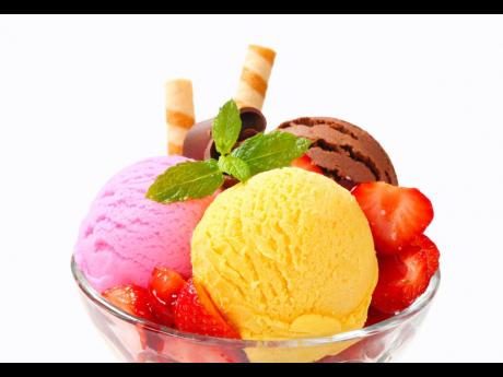 Ice cream sundae with strawberries and wafer sticks.