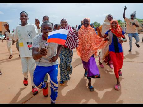 
Supporters of Niger’s ruling junta hold a Russian flag in Niamey, on August 6. 