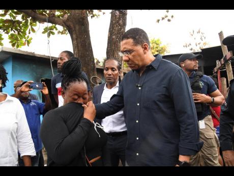 Prime Minister Andrew Holness (right) and St Catherine East Central Member of Parliament Alando Terrelonge (centre) speak with Subrina Stephenson, whose son was shot dead during Saturday morning’s rampage. The officials were touring the violence-torn com