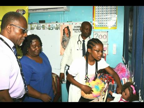 Ten-year-old Canadian-Jamaican philanthropist Jazmin Headley points out some of the items she donated to set up the ‘Jazmin Corner’ at the Paediatric Ward of the May Pen Hospital in Clarendon, which was opened on August 11. Looking on (from left) are: 