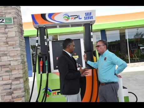 Andrew Williams, chief executive officer of Regency Petroleum, engages Daryl Vaz, Minister of Science, Energy, Telecommunications, and Transport, in a discussion during the opening of his company’s first service station in Westmoreland yesterday. The com