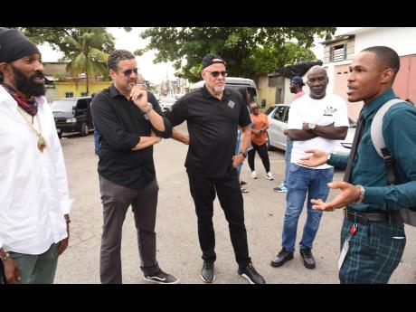 Kristoff James (right), a resident of James Street in central Kingston, explains how Project STAR has impacted his life to dancehall  artiste Spragga Benz; Julian Mair, chairman of the Jamaica Stock Exchange and co-sponsor and public funding lead advisor f
