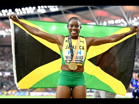 ABOVE: Jamaica’s Danielle Williams displays the national flag as she celebrates her World Championships win in the women’s 100m hurdles at the 2023 World Athletics Championships at the National Athletics Centre in Budapest, Hungary, yesterday.