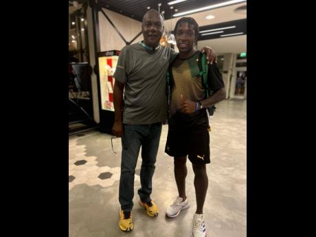 Photo by Raymond Graham 
Jamaica coach Bert Cameron hugs his country’s second world champion over 400 metres, Antonio Watson, hours after the 21-year-old achieved the feat in Budapest, Hungary, on Thursday.