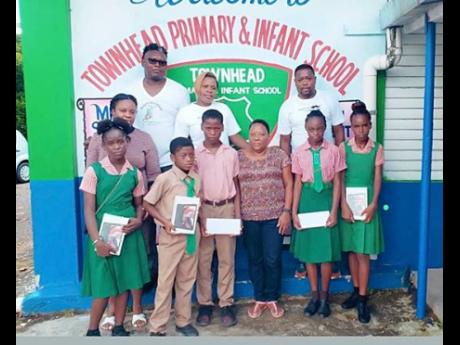 From left, back row: Dwayne Allen, Dagerian Palmer and Saundrae Palmer, all members of the Burnt Savanna Foundation, along with Michelle Coote-Dixon (front row, third right), guidance counsellor at Townhead Primary and Infant School, share photo time with 