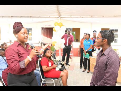 Kenneisha Gordon (foreground), student in the Business Administration in the Accounting/Finance and Management programme at the Portmore Community College (PCC), poses a question to Ricardo Dystant, chief of digital transformation and special projects, JN 