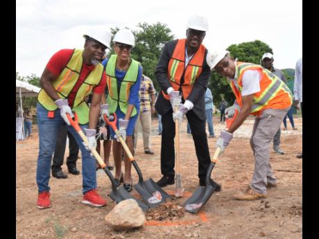 Fayval Williams (second left), member of parliament for St Andrew Eastern, takes part in breaking ground yesterday for a four-storey, 14 apartment complex on University Crescent in Papine, St Andrew, valued $600 million with Howard Johnson Jr (left), broke