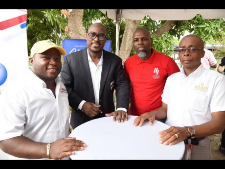 Richard ‘Richie B’ Burgess (second left), radio personality-turned-developer, poses with members of his development team shortly after they broke ground for a four-storey apartment building along University Crescent in Papine, St Andrew on Sunday. Memb