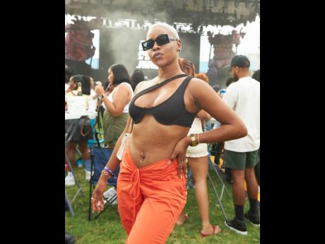 Carltonia Brown makes a real fashion statement in her asymmetrical black crop tee and plunging V-line orange joggers and Rick Owens sneakers.