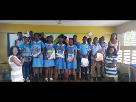 From left: Lilleth Connell-Lindo presenting a backpack to some of the 46 students who graduated from the Sheffield Primary School in Westmoreland which formed part of the Dr Norval Connell-led family donation of  approximately 300 backpacks to the entire s