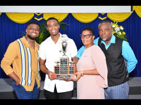 Top Nursing Student at Northern Caribbean University, Chevaugn Thomas (second left), celebrates with his family at the recent pinning ceremony, held at the Manchester-based institution. From left are brother, Devaughn Thomas; mother, Gloria Thomas, and fat